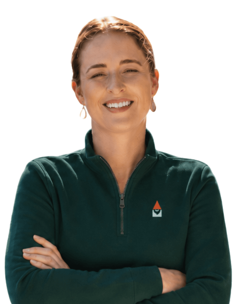 Danni Nelson, co-founder and licensee, arms folded, in a dark green Knome quarter-zip.