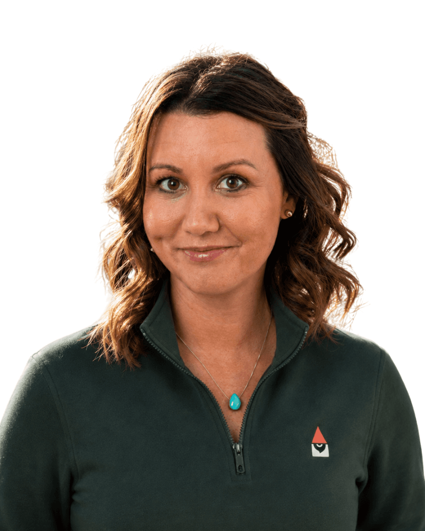 Haley Windram, executive admin, photographed from the shoulders up in a dark green Knome quarter-zip.